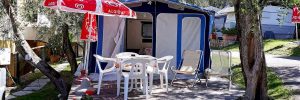 Roulotte-caravan Pizzini con veranda chiusa e area esterna con tavolino e sedie